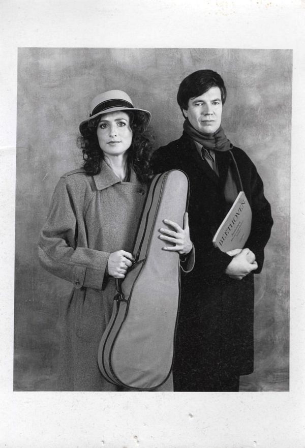 madeleine mitchell holding a violin case near a man