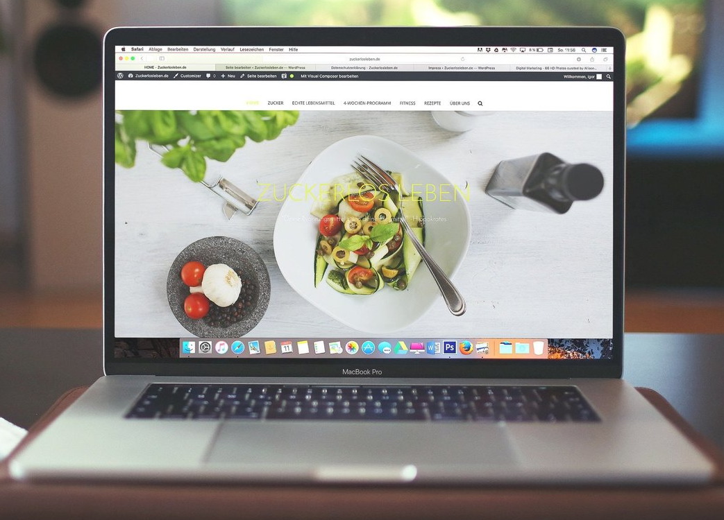 Laptop displaying a food blog with a salad photo on the screen