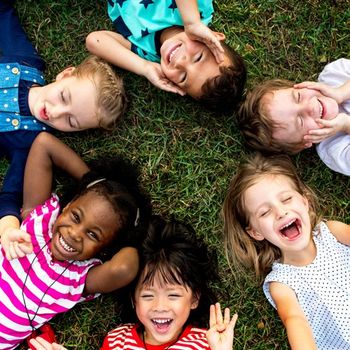 Kids Having Fun on Grass — Cheyenne, WY — The Backyard Child Care Center Kids Having Fun on Grass — Cheyenne, WY — The Backyard Child Care Center