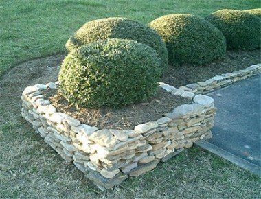 A stone planter with a bush in it