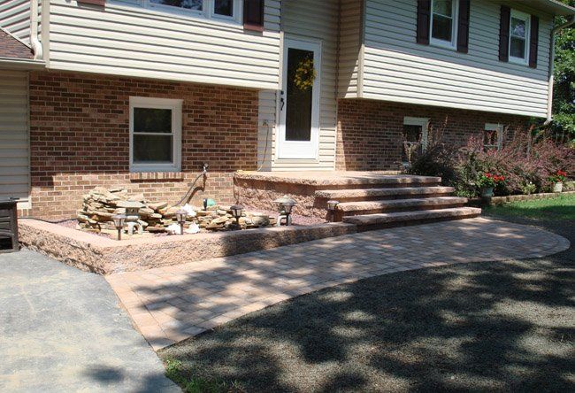 A brick house with stairs leading up to the front door