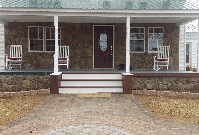 A house with a porch and rocking chairs on it