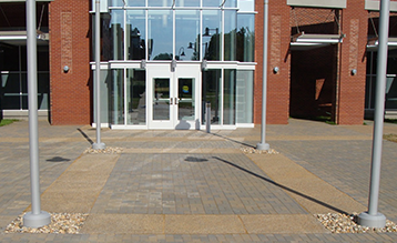 A brick building with a white door and a brick walkway leading to it