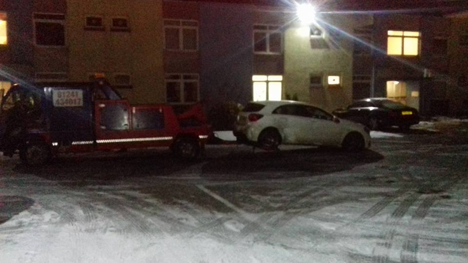 car being pulled by a recovery vehicle