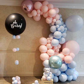 A bunch of pink and blue balloons with a black balloon that says oh baby