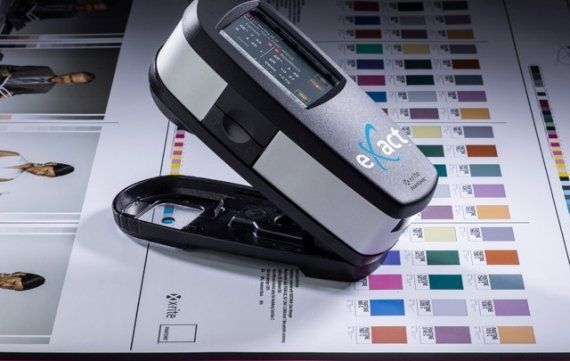 Close up of an eXact Spectrophotometer which measures accuracy of colours sat on a printed sheet of colour samples