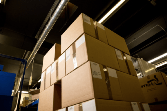 A large number of sealed, brown cardboard boxes stacked neatly on a pallet