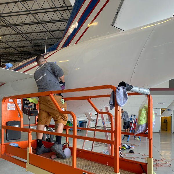 man cleaning airplane tail
