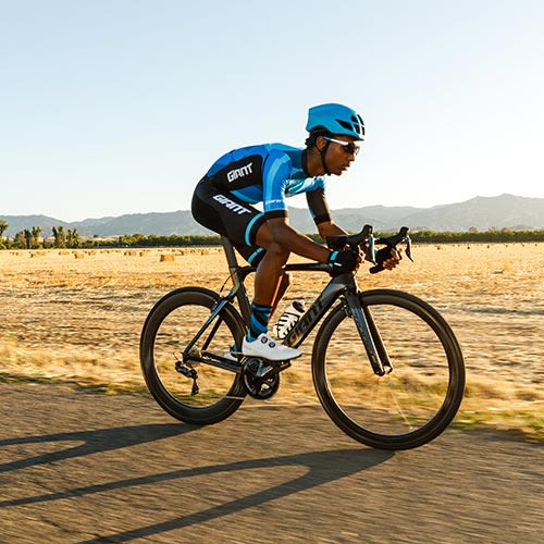 Man on the road riding a Silver Trek Road Bike