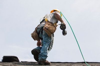 Roofer working on shingling a new roof - Exterior remodeling in Methuen, MA