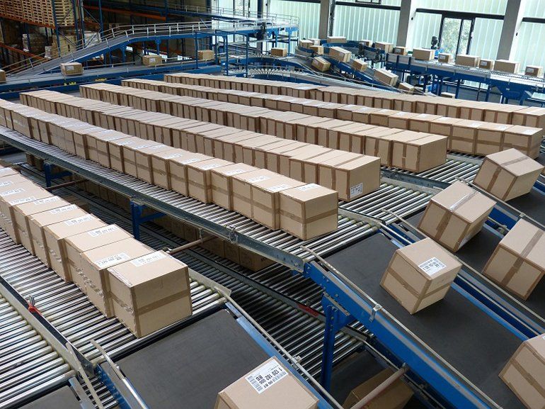A row of conveyor belts with many cardboard boxes