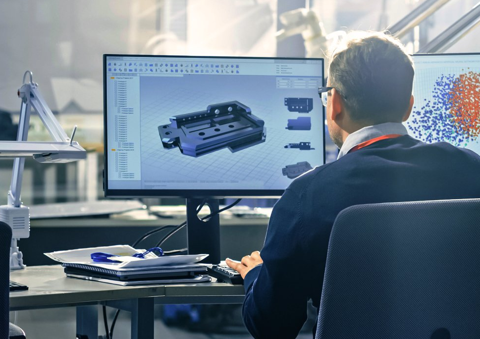 Man at a desk, designing a part in CAD