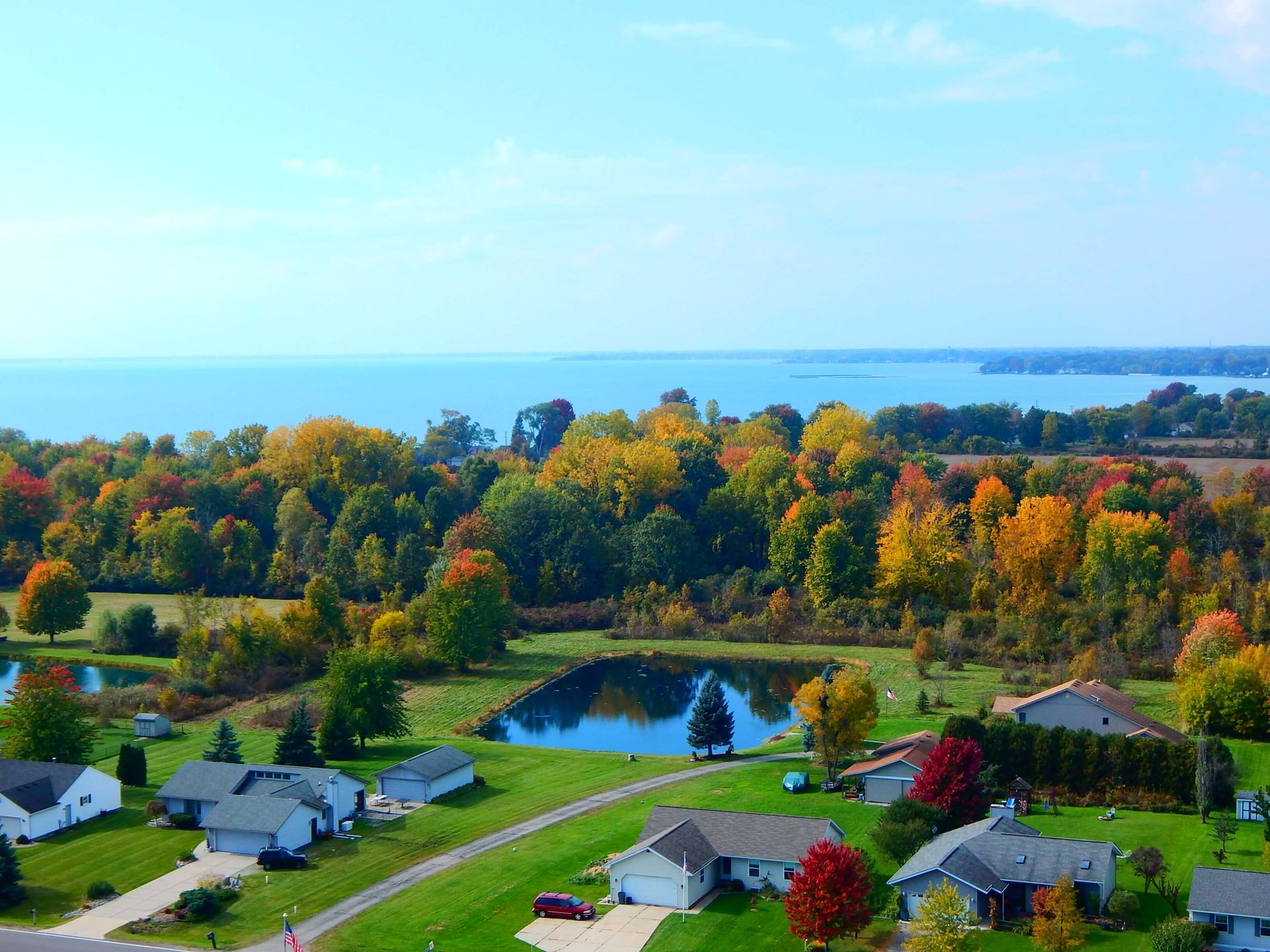 An aerial view of a residential area with a lake in the background.