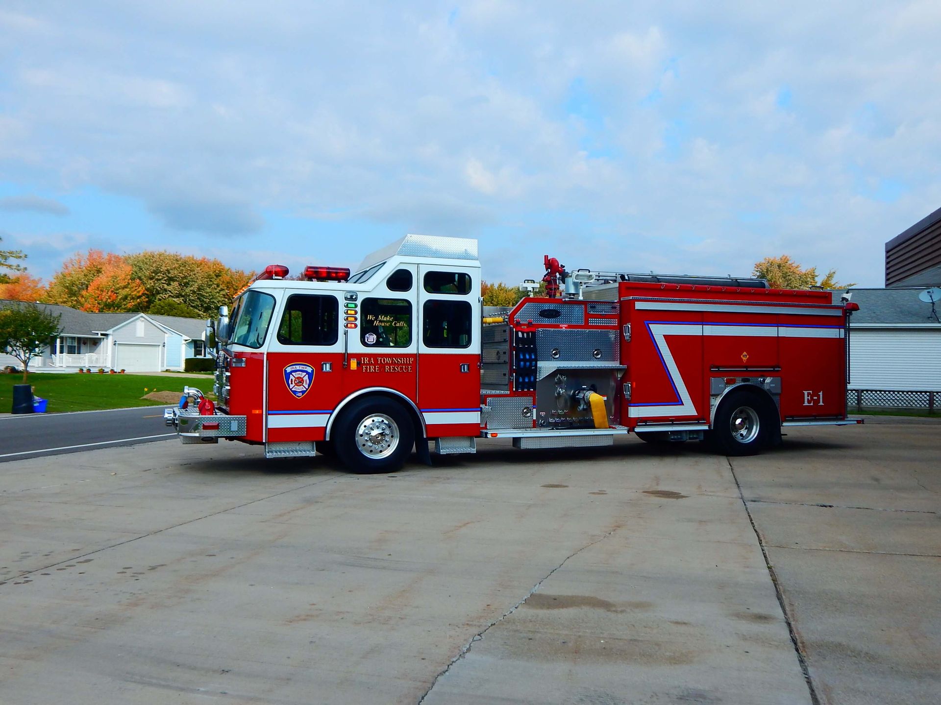 A red and white fire truck is parked on the side of the road.