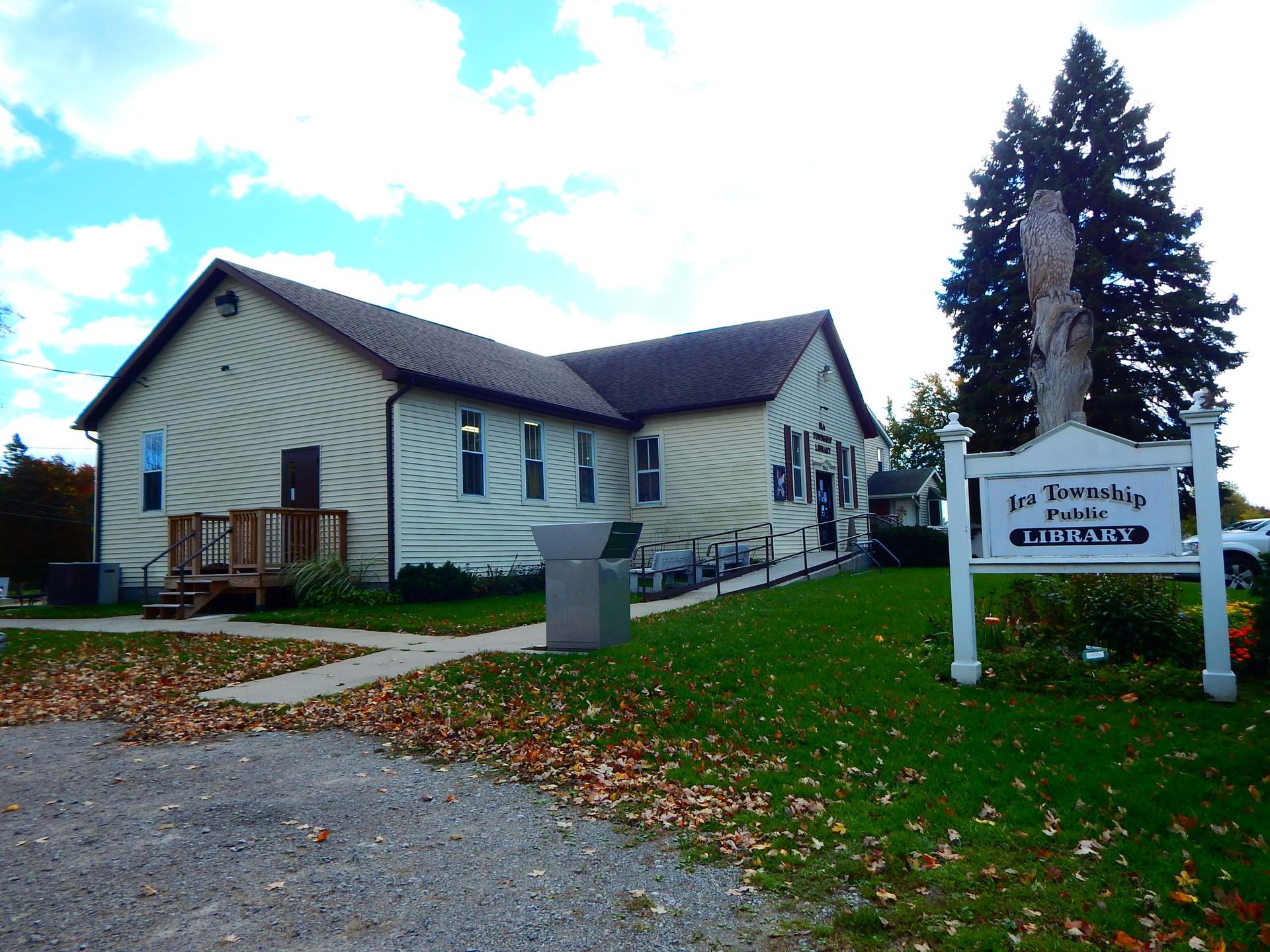 A sign in front of a building that says 'Ira Township Public Library' on it.