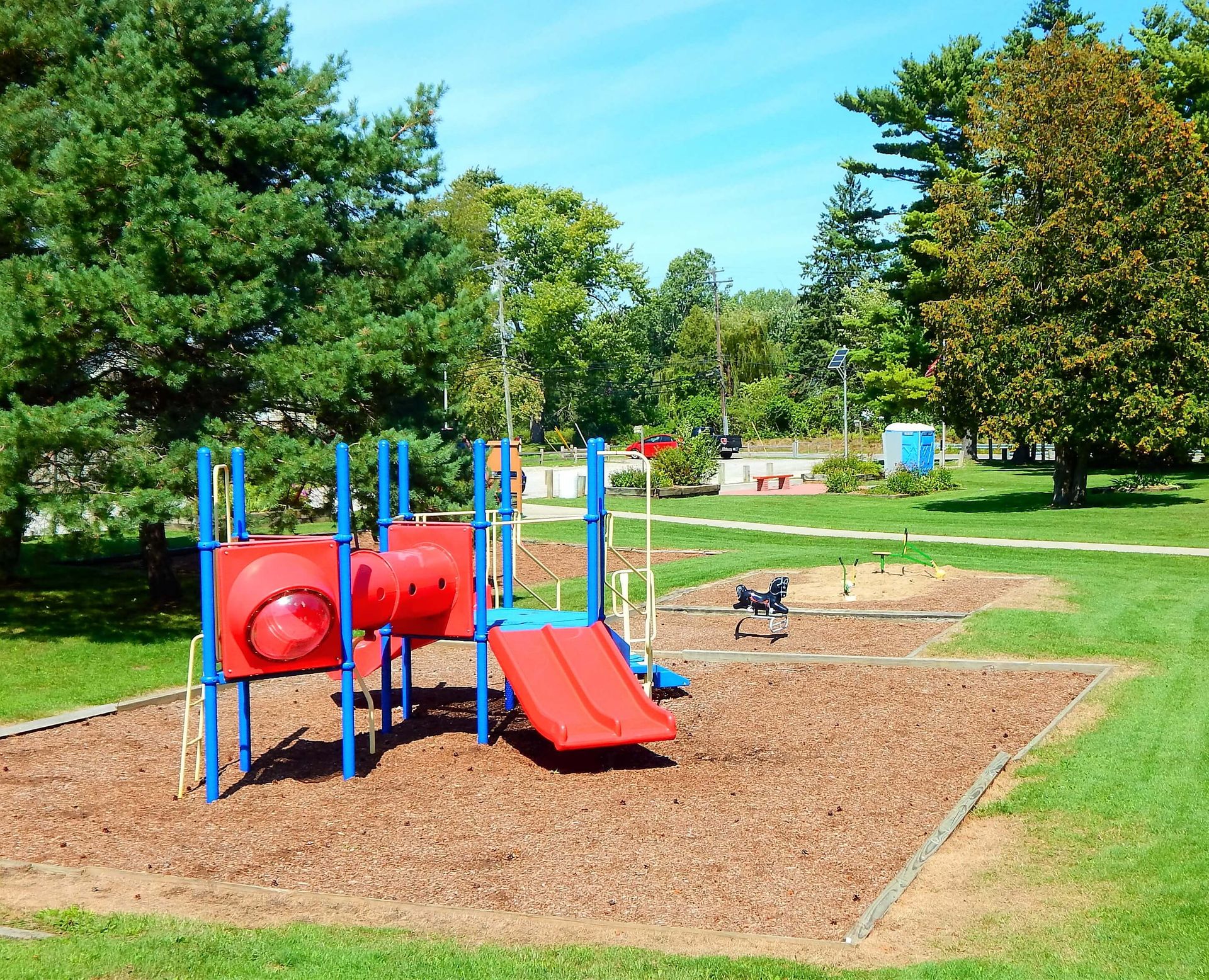 A red and blue playground set in a park