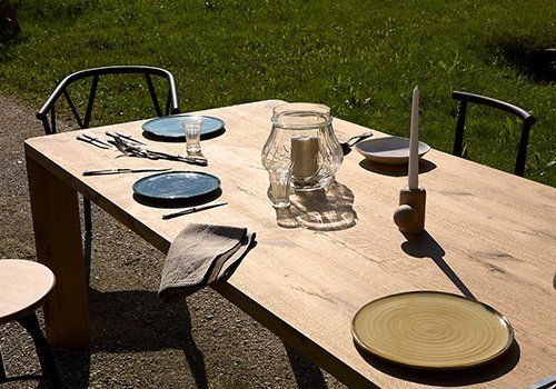 Tavola di legno con piatti,coperti e due candele