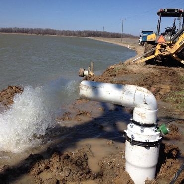 pipe with water coming out of it by a lake 
