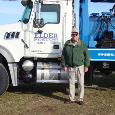 man standing by door of Elder truck 