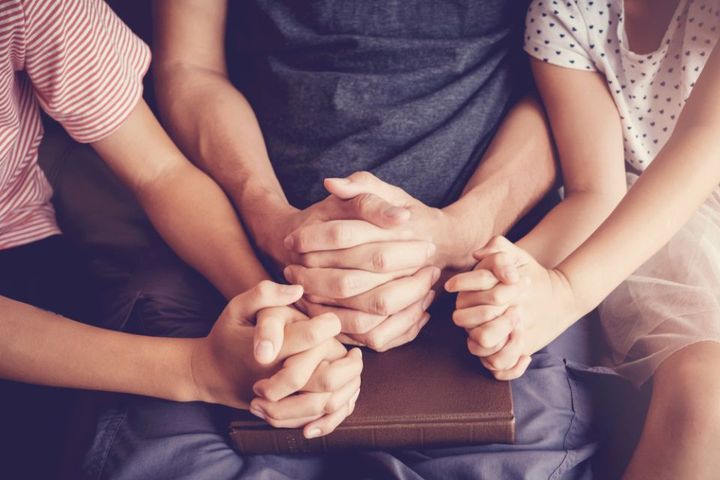 bambini e adulto che pregano