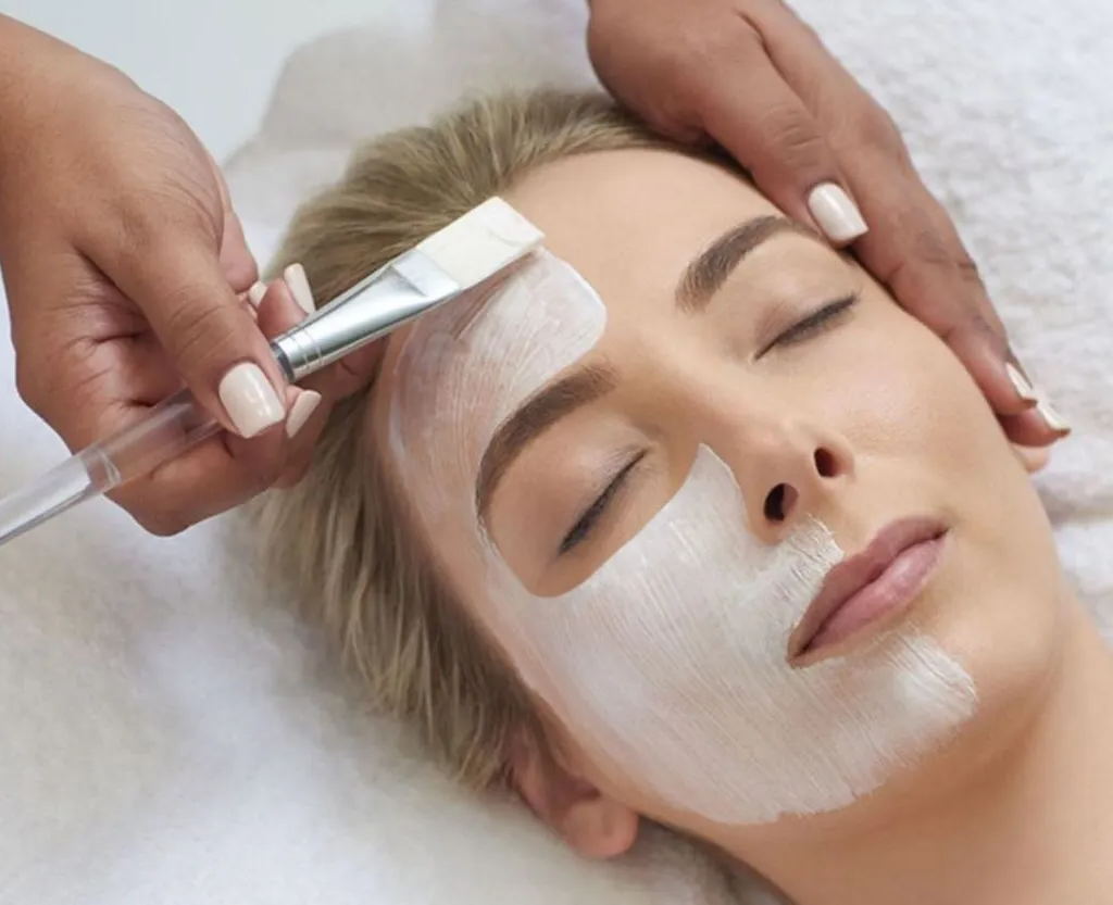 A woman is getting a facial treatment at a spa.