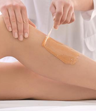 A woman is getting her legs waxed at a beauty salon.