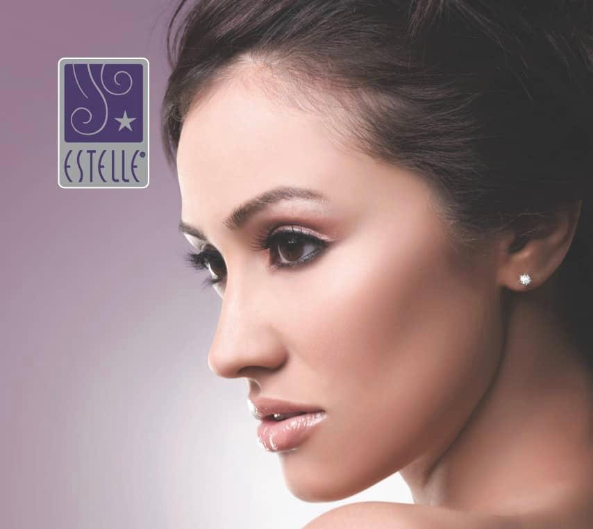 A close up of a woman 's face with the estelle logo in the background