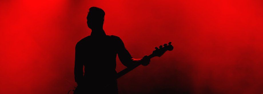 man playing bass guitar on stage