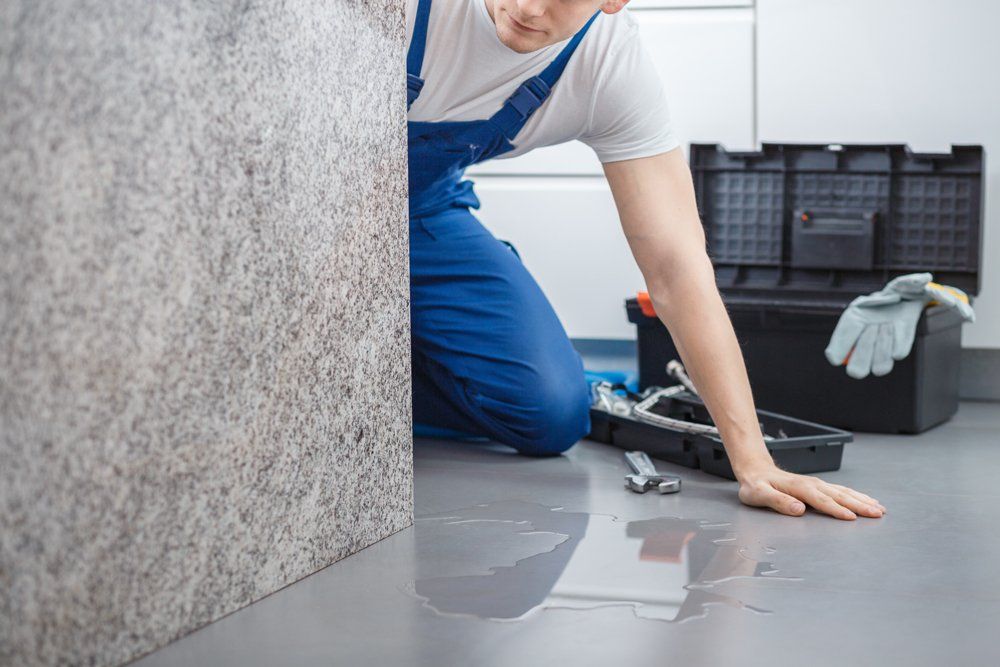 Water Damage Restoration — Plumber Looking at Water on the Floor in Ipswich, MA Water Damage Restoration — Plumber Looking at Water on the Floor in Ipswich, MA