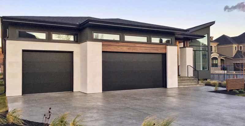 modern home with two black flush panel design garage doors 