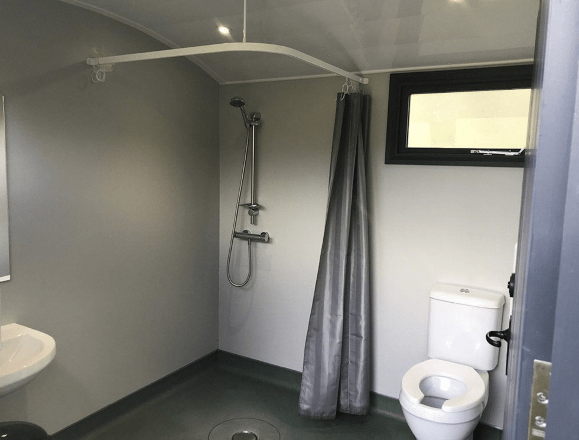 a bathroom with a toilet , sink and shower .