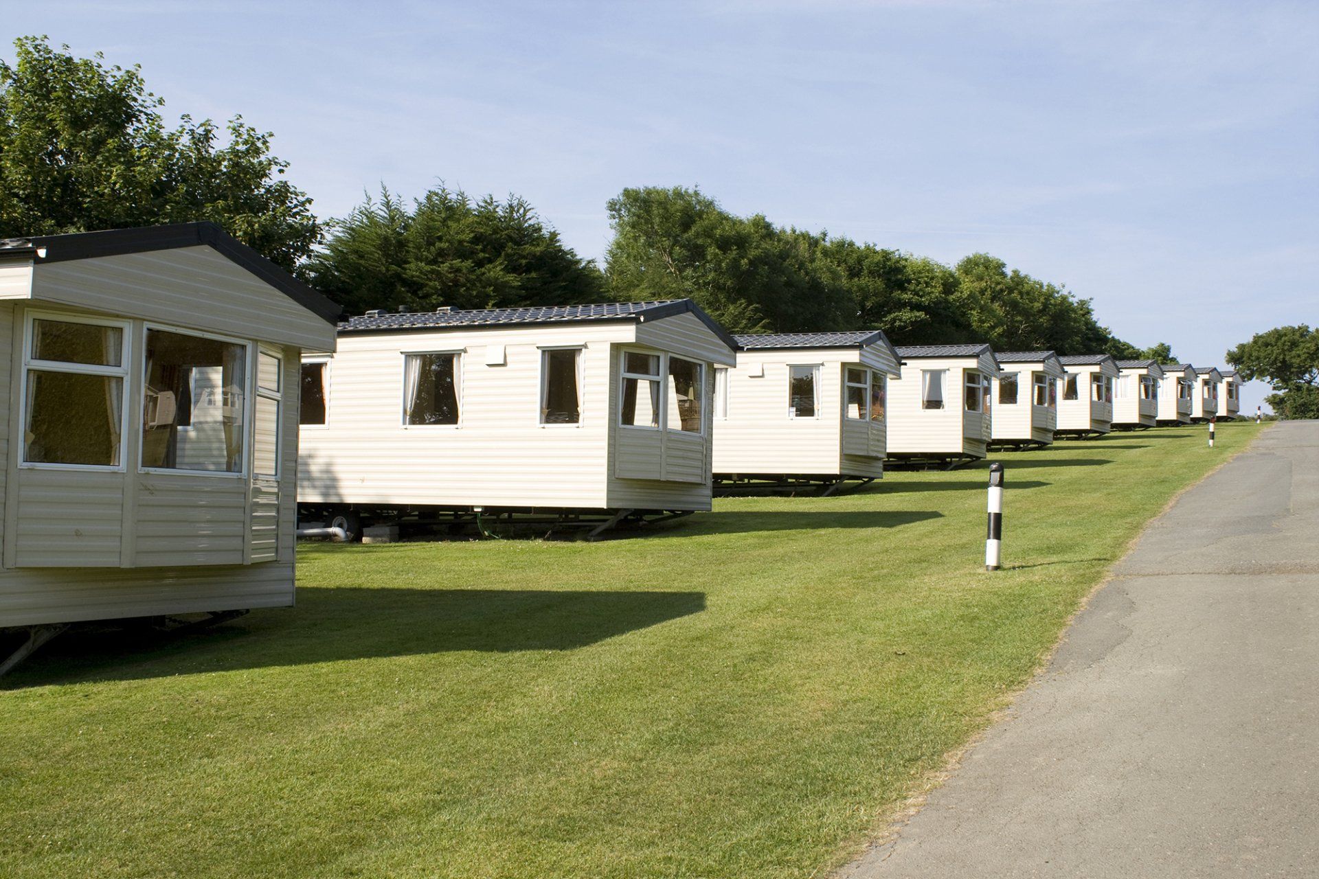 a row of mobile homes are parked on the side of a road