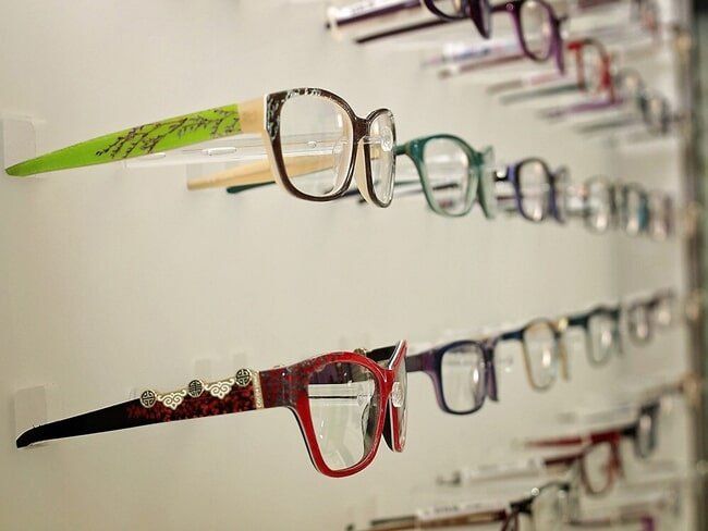 Frames - Clear Optometry In Bargara, QLD A row of glasses hanging on a wall in a store.