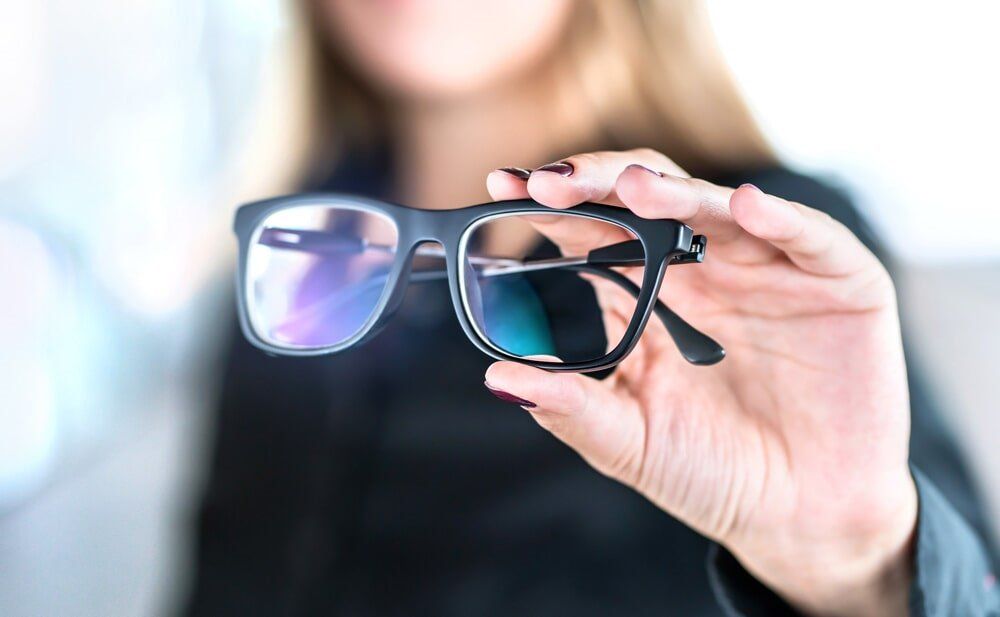 Woman Holding Glasses - Clear Optometry In Bargara, QLD Woman Holding Glasses - Clear Optometry In Bargara, QLD
