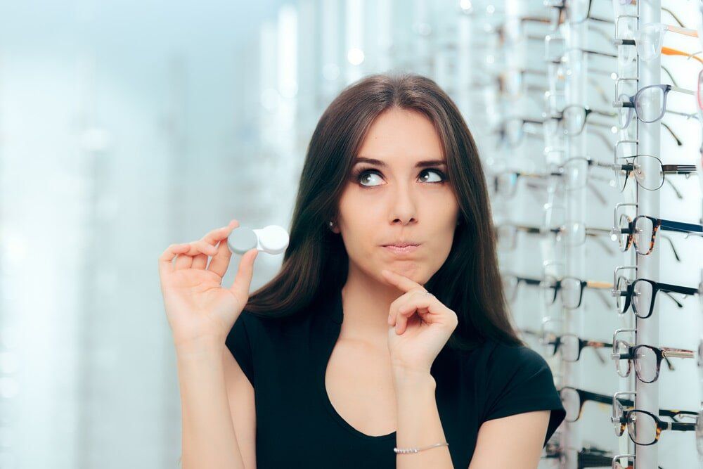 A woman is looking at glasses in an optical store.
