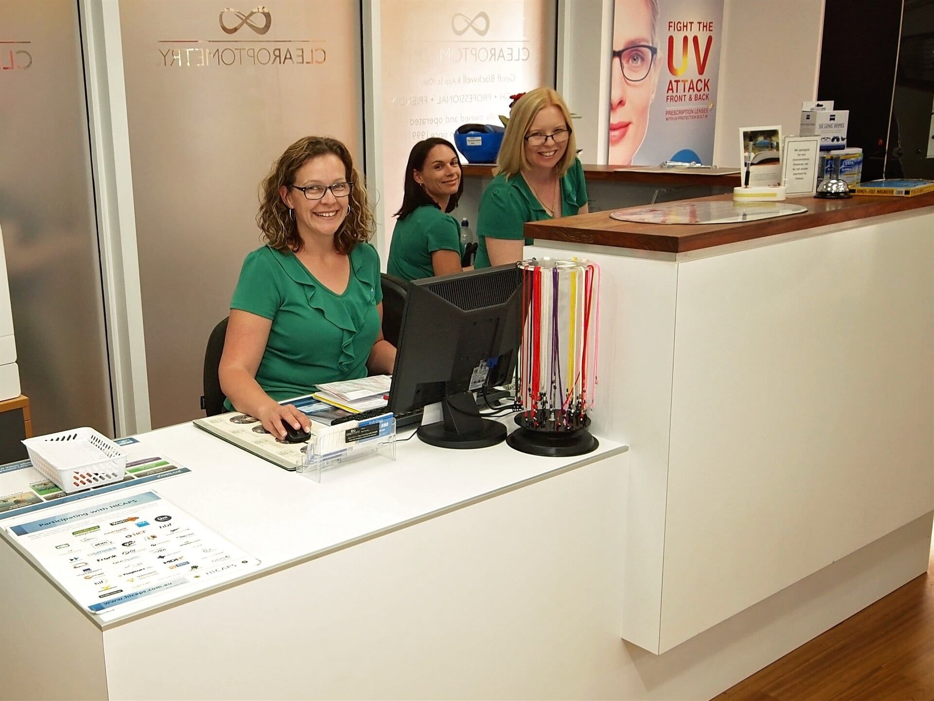 A group of women are sitting at a desk in front of a computer.