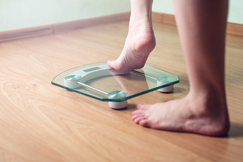 individual stepping on the weigh scale