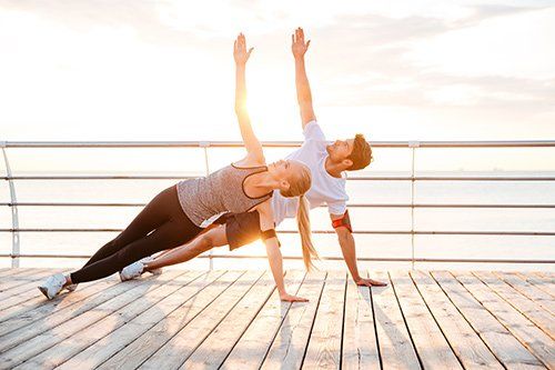 couple exercising in open