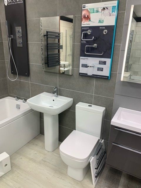 tiled bathroom with bath and shower enclosure