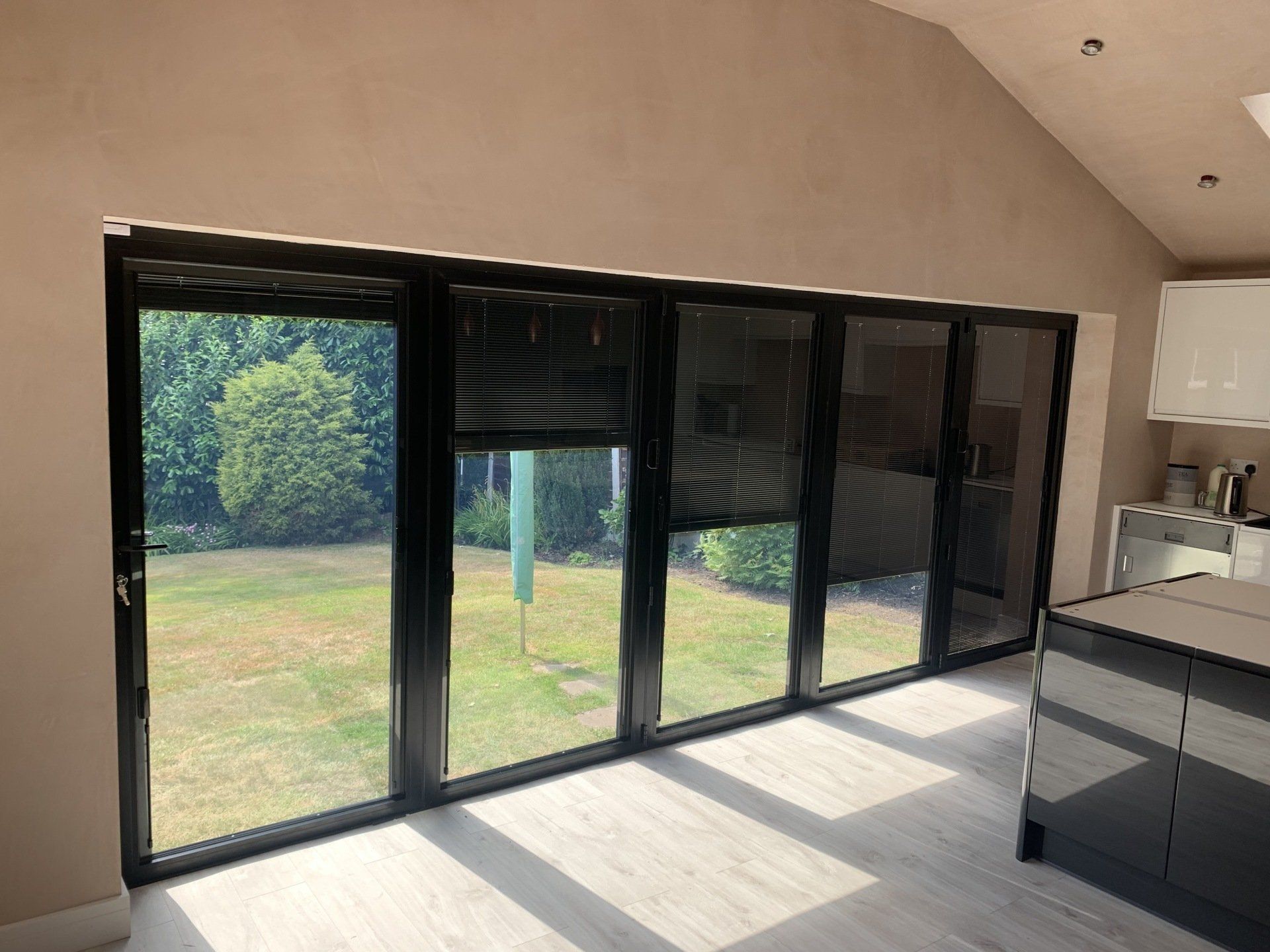 black aluminium bifold doors installed in Banford rochdale with blinds