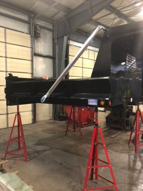 A black piano is sitting on red stands in a garage