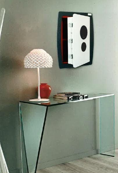 una cassaforte al muro e una consolle in vetro