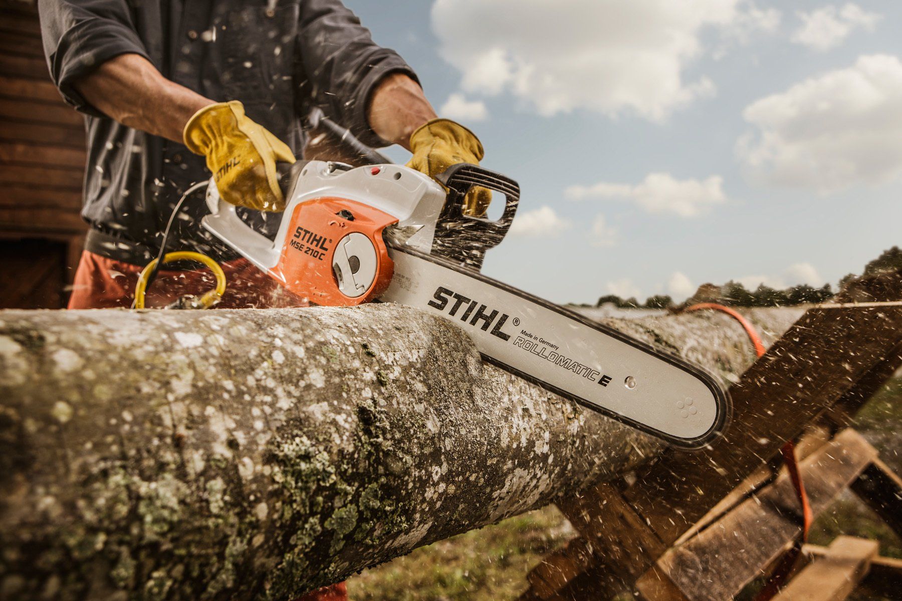 a man is cutting a log with a chainsaw .