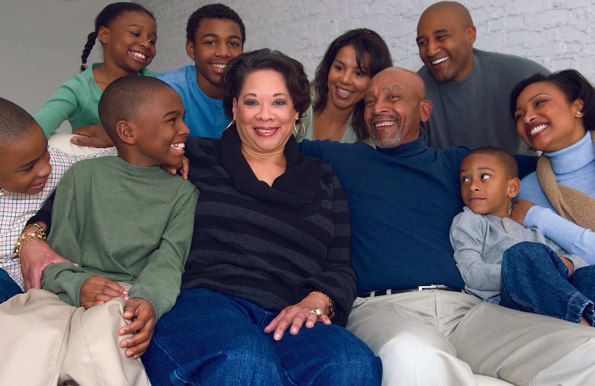 A middle-age woman sits in the middle of her family.