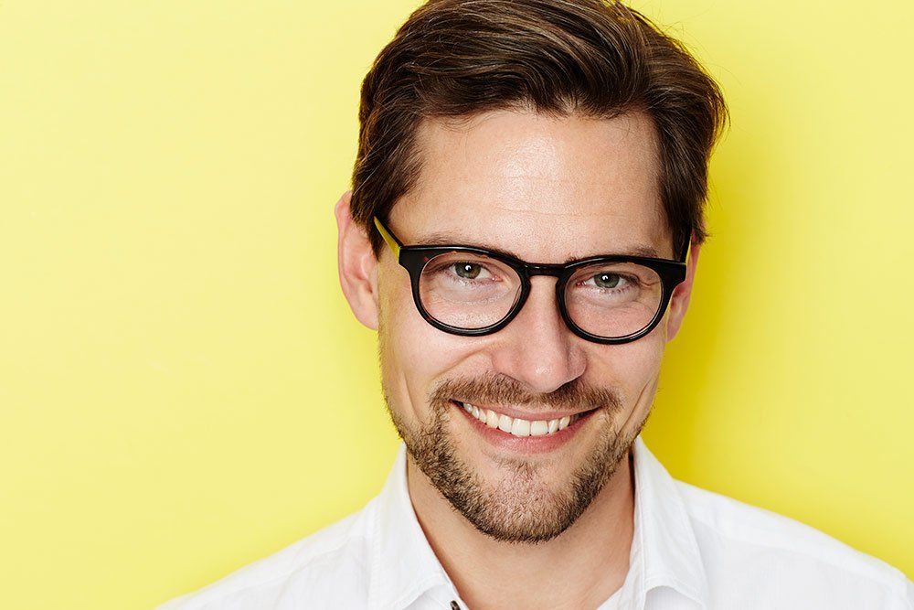 smiling man against yellow background
