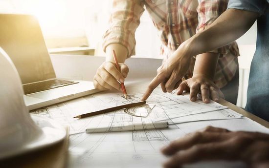 Due uomini modificando la pianta del progetto