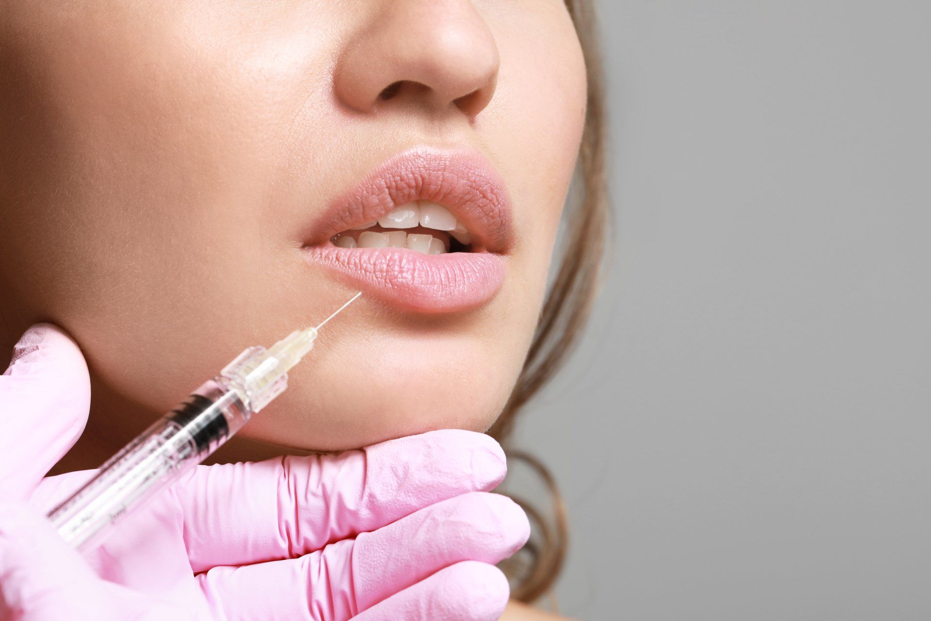 Eine Frau bekommt eine Botox-Injektion in die Lippen.