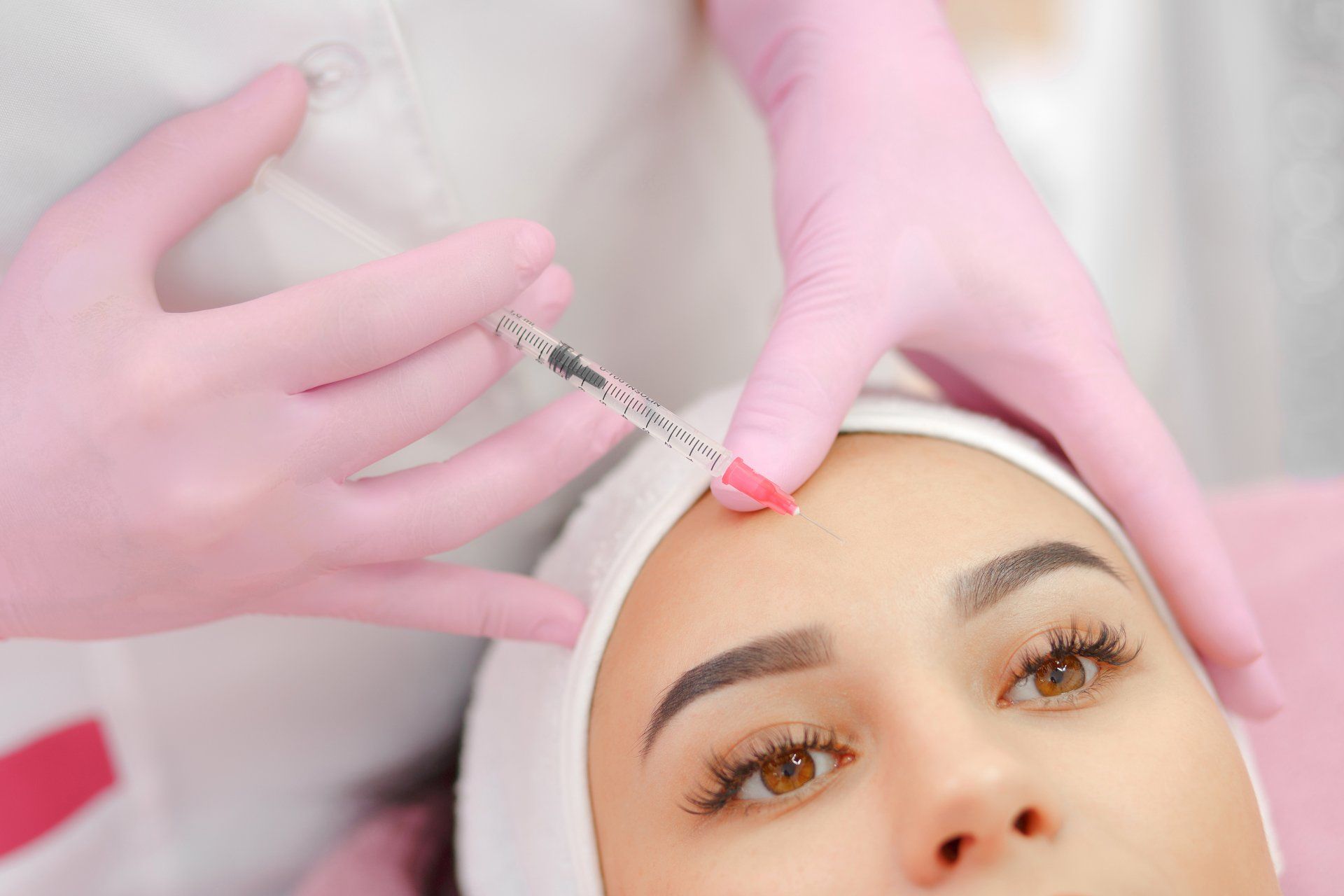 Eine Frau bekommt eine Botox-Injektion in die Stirn.