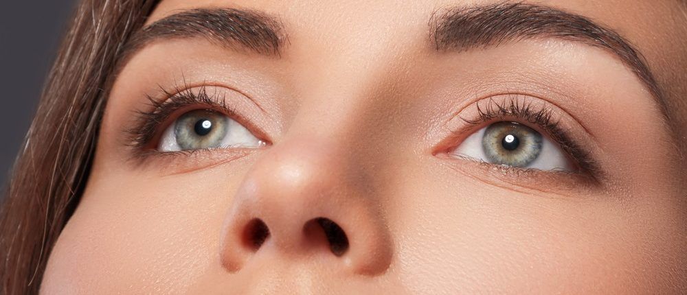 Eine Nahaufnahme der Augen und Nase einer Frau, die nach oben blickt.