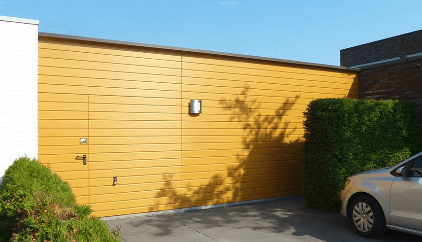 Een auto staat geparkeerd voor een gele garagedeur.
